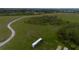 Aerial view of a land parcel with a winding dirt road and some buildings at 11320 Montevista Rd, Clermont, FL 34711