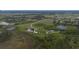 Aerial view of a property with a pond, a house, outbuildings, and lush greenery at 11320 Montevista Rd, Clermont, FL 34711