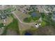 Aerial view of a property with a house, outbuildings, and a pond at 11320 Montevista Rd, Clermont, FL 34711