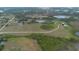 Expansive aerial view of a large property featuring green fields, ponds, and access roads amidst lush greenery at 11320 Montevista Rd, Clermont, FL 34711