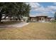 Spacious home with a wraparound porch and metal roof, complemented by mature trees and a private driveway at 11320 Montevista Rd, Clermont, FL 34711