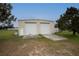 Two-bay garage with concrete driveway and tan siding at 11320 Montevista Rd, Clermont, FL 34711