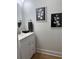 Stylish half-bathroom featuring a white vanity, round mirror, and decorative wall art at 12850 Lexington Summit St, Orlando, FL 32828