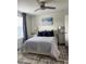 Well lit bedroom has ceiling fan, large window, decorative rug, and stylish decor at 12850 Lexington Summit St, Orlando, FL 32828