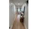 Hallway with wood floors leading to a well-lit living space, offering a bright and open feel at 12850 Lexington Summit St, Orlando, FL 32828