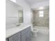 Updated bathroom with modern vanity and shower-over-tub with stone tile at 13 N Observatory Dr, Orlando, FL 32835