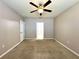 A bedroom features a carpeted floor, neutral walls, a ceiling fan, and a doorway leading to the bathroom at 133 Grove Branch Rd, Winter Haven, FL 33880