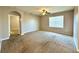 A carpeted bedroom features an archway entrance, a ceiling fan, and a window with blinds to let in natural light at 133 Grove Branch Rd, Winter Haven, FL 33880