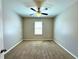 A carpeted bedroom offers neutral walls, a ceiling fan, and a window with horizontal blinds at 133 Grove Branch Rd, Winter Haven, FL 33880