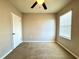 Neutral bedroom featuring carpet, a ceiling fan, and a window for natural light at 133 Grove Branch Rd, Winter Haven, FL 33880