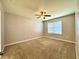 The carpeted bedroom boasts neutral walls, a ceiling fan, and a window with blinds allowing natural light at 133 Grove Branch Rd, Winter Haven, FL 33880