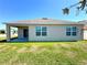 Back exterior featuring beige siding, windows, and a covered patio at 133 Grove Branch Rd, Winter Haven, FL 33880