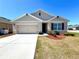 Charming single-story home with a well-maintained lawn, two car garage, and neutral-toned exterior at 133 Grove Branch Rd, Winter Haven, FL 33880
