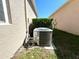 Exterior shot of an HVAC unit near a neutral-colored building and small garden at 133 Grove Branch Rd, Winter Haven, FL 33880