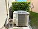 Outdoor air conditioning unit surrounded by foliage with labeled safety information at 133 Grove Branch Rd, Winter Haven, FL 33880