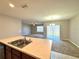 Open-concept kitchen island that looks out to the carpeted living area and a door to the back yard at 133 Grove Branch Rd, Winter Haven, FL 33880