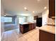 Open kitchen featuring an island with a sink, tile floors, and a seamless view into the living area at 133 Grove Branch Rd, Winter Haven, FL 33880