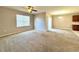 Bright, carpeted living area with a ceiling fan, windows, and sliding doors offering plenty of natural light at 133 Grove Branch Rd, Winter Haven, FL 33880