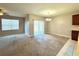 Spacious living area with carpeting, a ceiling fan, and sliding glass doors that lead to a outdoor space at 133 Grove Branch Rd, Winter Haven, FL 33880