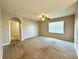 Bright living room featuring neutral walls, carpeting, a ceiling fan, and a doorway leading to another room at 133 Grove Branch Rd, Winter Haven, FL 33880
