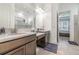 Bright bathroom features double sink vanity, tiled floors, and shower with glass door at 1335 Zeek Ridge St, Clermont, FL 34715