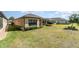 Lovely backyard with green lawn and tropical landscaping plus a screened in porch, creating a serene outdoor living space at 1335 Zeek Ridge St, Clermont, FL 34715