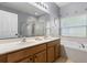 Bathroom featuring double sinks, a large tub, and a separate glass-enclosed shower at 14556 Unbridled Dr, Orlando, FL 32826