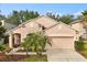 Charming, peach-colored two-story home with a well-manicured lawn and a two car garage at 14556 Unbridled Dr, Orlando, FL 32826