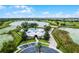 Aerial view of a community clubhouse with a resort-style pool, surrounded by lush landscaping and overlooking a serene lake at 14722 Porter Rd, Winter Garden, FL 34787
