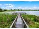 Picturesque fishing pier extends over a tranquil lake dotted with lily pads, offering a serene recreational space for residents at 14722 Porter Rd, Winter Garden, FL 34787