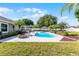 Lush backyard featuring a sparkling pool, two cabanas, and verdant landscaping at 150 Dempsey Way, Orlando, FL 32835