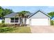 Charming single-story home featuring a gray exterior, well-maintained landscaping, and a brick-paved driveway leading to a two-car garage at 150 Dempsey Way, Orlando, FL 32835