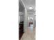Hallway with neutral walls and tile flooring, connecting various rooms with contrasting hardwood floors at 150 Dempsey Way, Orlando, FL 32835
