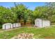 Backyard with storage sheds and mature trees at 151 Naranja Rd, Debary, FL 32713