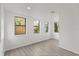 Bright bedroom featuring hardwood floors and three windows overlooking the backyard at 151 Naranja Rd, Debary, FL 32713
