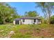 Exterior side view of the home with sliding glass door and spacious backyard at 151 Naranja Rd, Debary, FL 32713