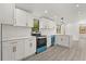 Modern kitchen featuring white cabinets, gold hardware, and stainless steel appliances at 151 Naranja Rd, Debary, FL 32713