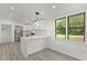 Bright kitchen features white cabinets, marble countertops, and a stainless steel refrigerator at 151 Naranja Rd, Debary, FL 32713