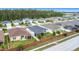 An aerial view of a neighborhood featuring single-Gathering homes with well-maintained lawns and brick fences at 16369 Yelloweyed Dr, Clermont, FL 34714