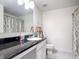 Bathroom featuring granite countertops and a decorative shower curtain at 16369 Yelloweyed Dr, Clermont, FL 34714