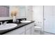Bright bathroom features double sinks, a black granite countertop, and updated fixtures at 16369 Yelloweyed Dr, Clermont, FL 34714