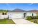 Single-story home boasts a neat front yard, two-car garage, and well-maintained landscaping at 16369 Yelloweyed Dr, Clermont, FL 34714