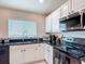 Well-lit kitchen boasting granite countertops and black appliances at 16369 Yelloweyed Dr, Clermont, FL 34714