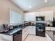 Charming kitchen featuring white cabinets, black appliances, and stylish backsplash at 16369 Yelloweyed Dr, Clermont, FL 34714