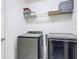 Modern laundry room equipped with newer front load washer and dryer, and shelving at 16369 Yelloweyed Dr, Clermont, FL 34714