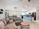 Spacious open-plan living area features a comfy couch, dining space, and a modern kitchen at 16369 Yelloweyed Dr, Clermont, FL 34714