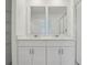 A bathroom featuring double vanity sinks with white cabinets at 16403 Bird Of Paradise Ave, Clermont, FL 34714