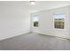 Bright, carpeted bedroom with two windows offering natural light at 16403 Bird Of Paradise Ave, Clermont, FL 34714