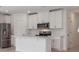 Well-equipped kitchen with stainless steel appliances, white cabinets, and a functional island at 16403 Bird Of Paradise Ave, Clermont, FL 34714