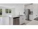 Modern kitchen features stainless steel appliances, white cabinets, tile flooring, and a center island with a sink at 16403 Bird Of Paradise Ave, Clermont, FL 34714
